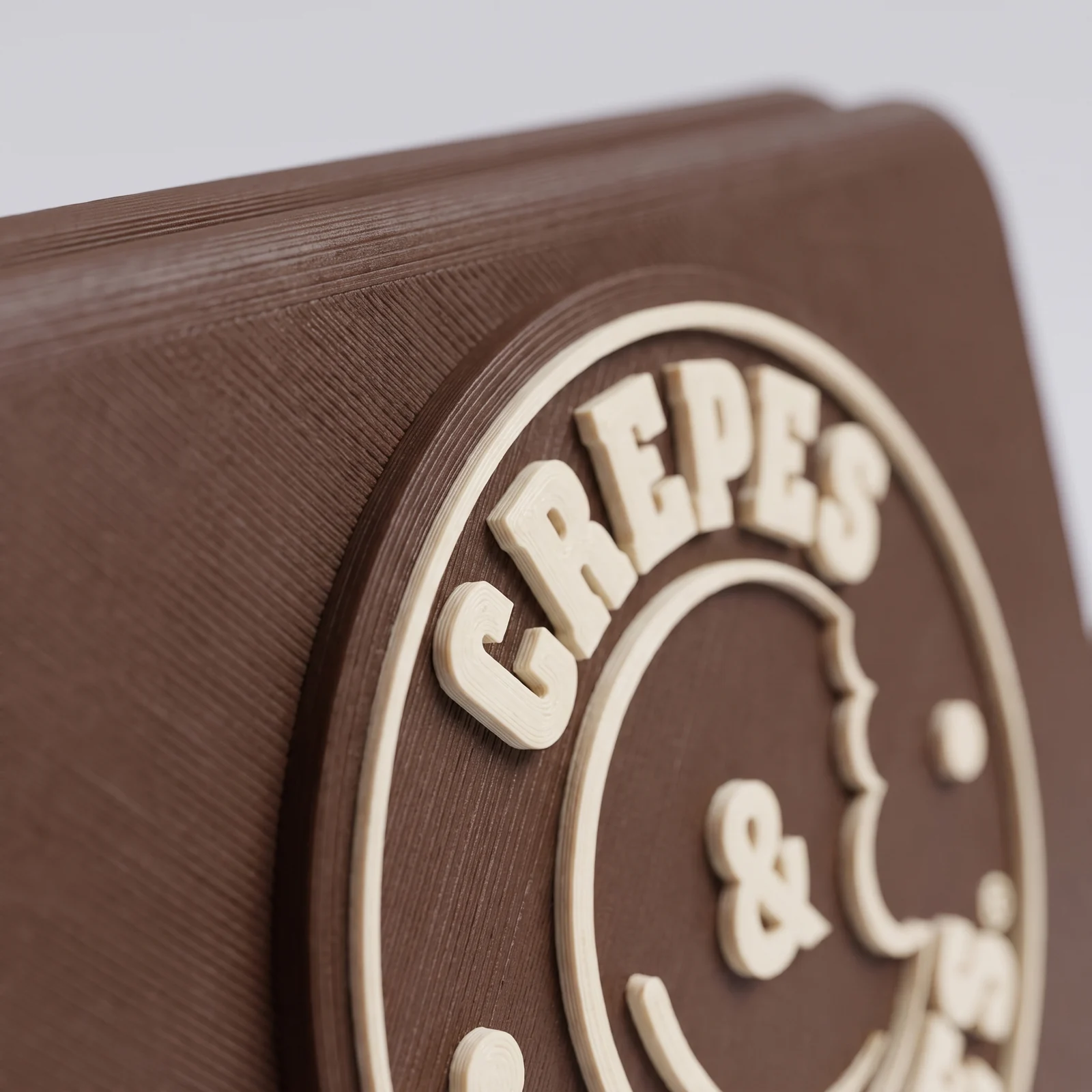 Detalle de las capas en el relieve del logo de Crepes & Waffles